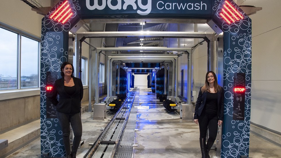 Waxys högteknologiska tvättgata har kapacitet att tvätta upp till 60 bilar i timmen. Helena Olafsson, anläggningschef (t.v.), och Elli León, VD (t.h.), är nöjda med öppningen av Waxy i Uppsala – deras hittills största anläggning i Sverige.