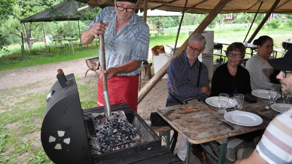 Kalvefalls egenproducerade grillkol öses upp till gästerna av Olle Forsell. Här är det Kerstin Hildebrand, med sambon Bengt och sonen Kalle med familj som ska få grilla.