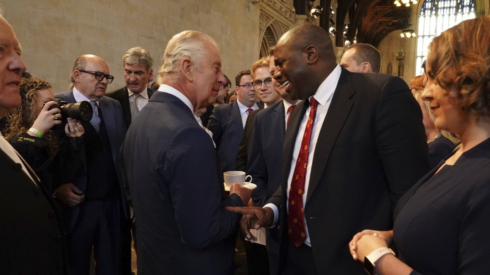 Här Storbritanniens kung Charles III i samspråk med parlamentsledamoten David Lammy vid en mottagning i Westminister inför den kommande kröningen.