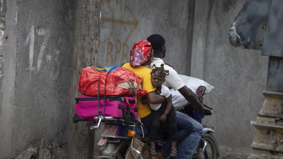 En familj har packat sina tillhörigheter på en motorcykel för att lämna sitt hem, då det sker våldsamma drabbningar mellan väpnade gäng i deras område i Port-au-Prince. Bilden togs den 28 april i år. Arkivbild.