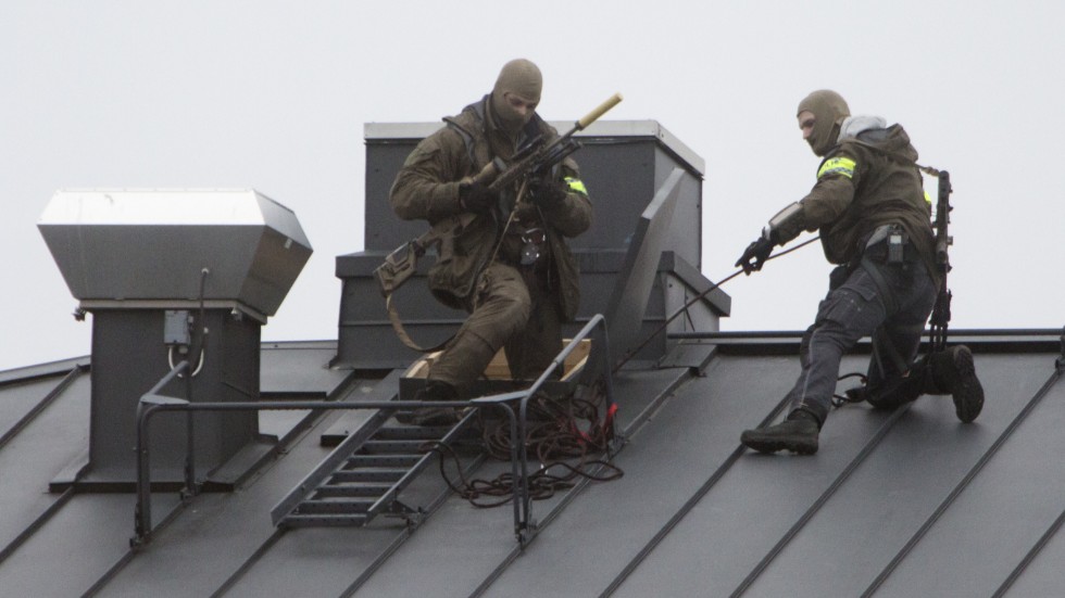 På taket till en fastighet på Fredsgatan kunde dessa poliser synas på onsdageftermiddagen.