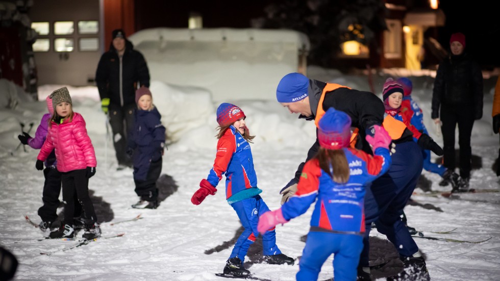Tränaren Håkan falk blir tagen av dottern Hilma Pirak Falk under lekens gång. Jokkmokks skidklubb inledde säsongen med en blandning av lek och träning.