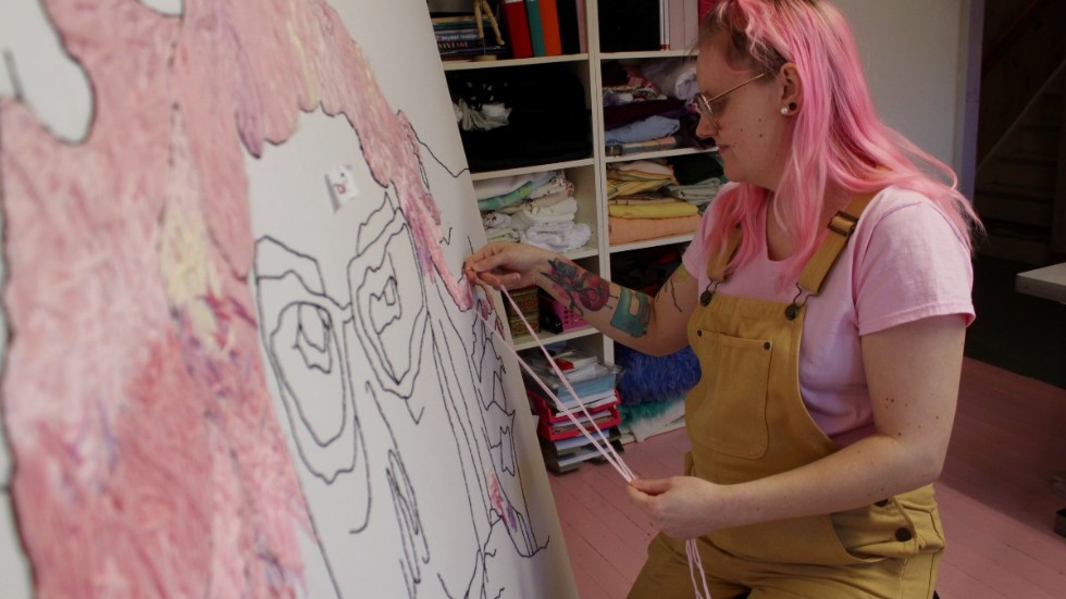 Elin Samuelsson när hon jobbar på ett större självporträtt i ateljén hemma i Vimmerby. 