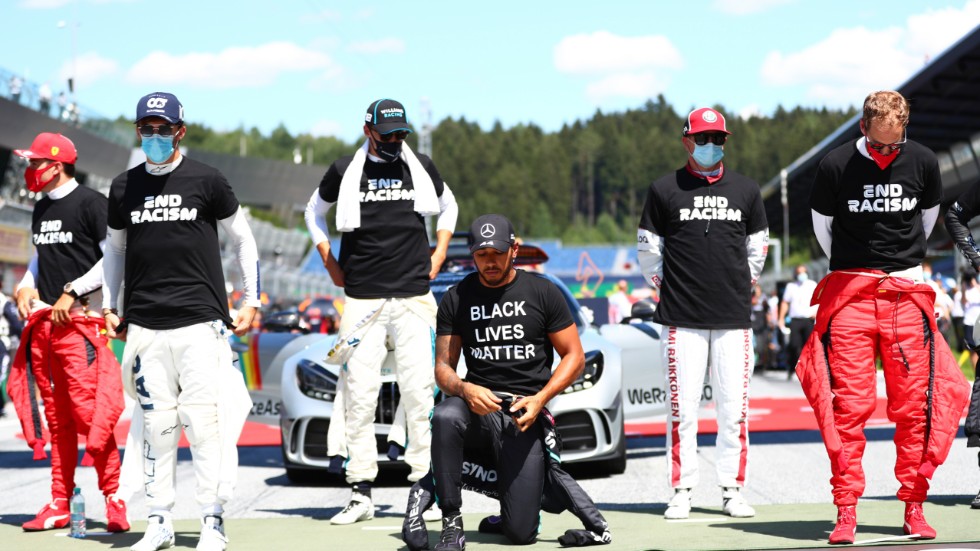 Lewis Hamilton knäböjer inför F1-premiären i Österrike.