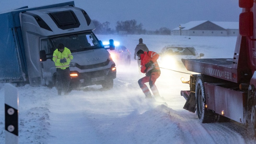 Polisen spärrar av riksväg 13 medan en lastbil bärgas ur diket i det kraftiga snödrevet norr om Ystad.