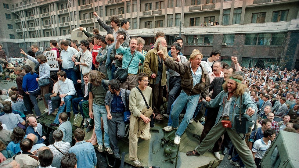 Demonstranter klättrar upp på pansarfordon som är på väg mot Röda torget. Bild från 19 augusti 1991.