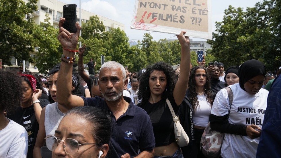 "Hur många Nahel har inte filmats?" Så står det på det plakat som en demonstrant håller upp efter att en 17-årig pojke skjutits till döds av polis i Frankrike.
