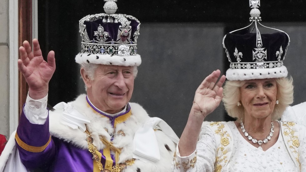 Storbritanniens nykrönte kung Charles och drottning Camilla vinkar till folkhavet framför Buckingham Palace efter att kröningsceremonierna är avklarade.