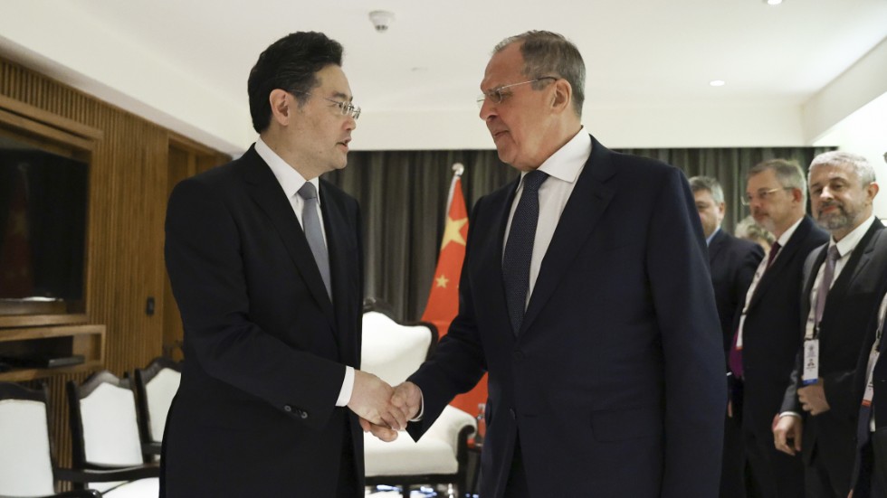 Qin Gang skakar hand med Rysslands utrikesminister Sergej Lavrov under ett utrikesministermöte inom den asiatiska samarbetsorganisationen SCO i indiska Goa den 4 maj.