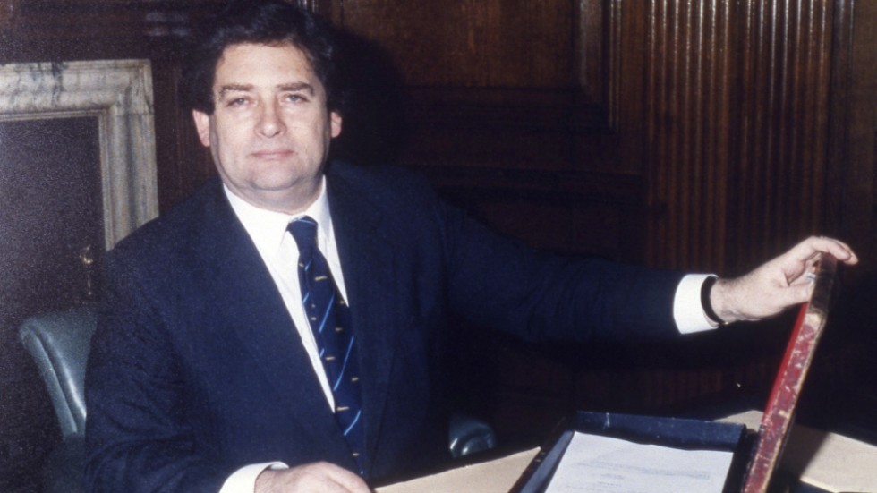 Nigel Lawson och "budgetlådan". Den användes vid den brittiska motsvarigheten till Sveriges budgetpromenad, då finansministern tar sitt budgetförslag till parlamentet. Bilden är från våren 1987.