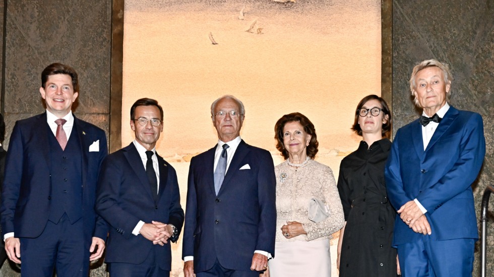 Andreas Norlén, Ulf Kristersson, kung Carl Gustaf, drottning Silvia och konstnärerna Frida Lindberg och Lars Lerin i trapphallen på slottet där väven hänger.