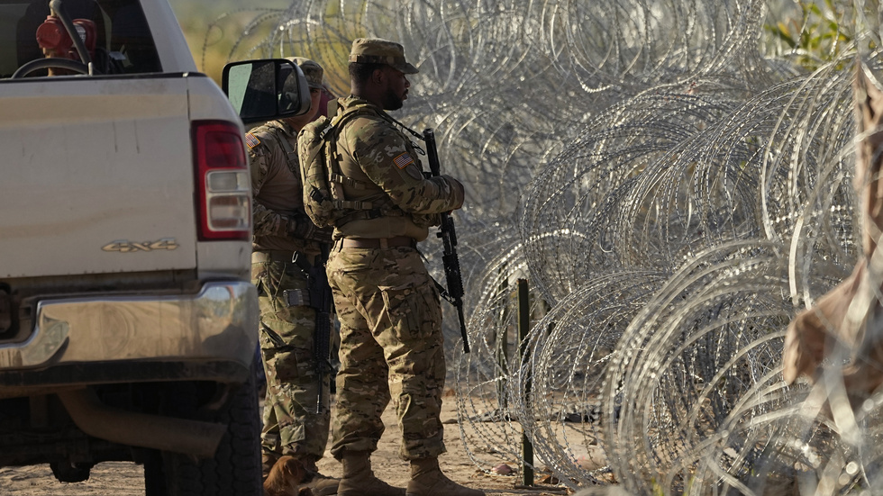 Gränsvakter vid barriär och traggtråd vid USA:s gräns mot Mexiko, vid Rio Grande och Eagle Pass i delstaten Texas.