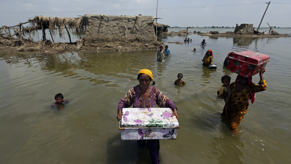 Kvinnor räddar sina ägodelar från sina översvämmade hem i Sindh-provinsen i Pakistan 2022.