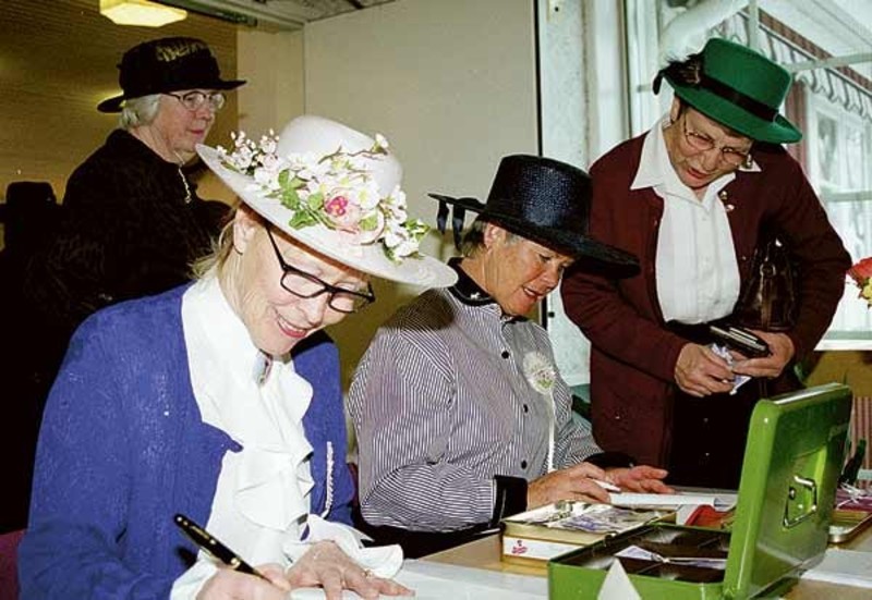 Febe Lindén och Britt-Marie Andersson från Eksjö tar ut en avgift av Anne-May Walfridsson från Edshult. Bakom syns ordföranden Ingegerd Westberg.