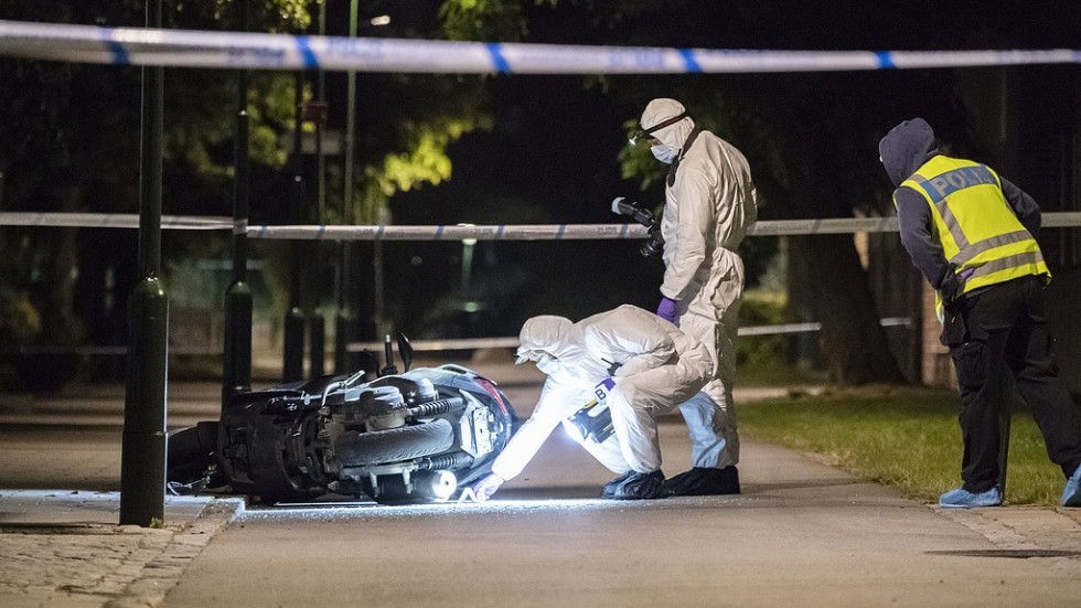 Polisens kriminaltekniker undersöker en moped på en gångbana vid Lindängsplan i Malmö efter att en man skjutits.