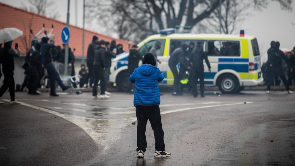 En ung pojke betraktar det våldsamma upploppet i Skäggetorp på skärtorsdagen den 14 april 2022.