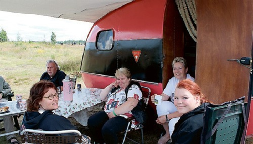 Marita Johansson och Karin och Frida Freij (närmast kameran) har fått besök av ett par kaffegäster vid Marita och Morgan Johanssons tillfixade husvagn.