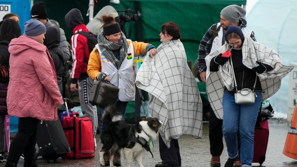 Människor på flykt från Ukraina får filtar i grannlandet Polen på söndagen.