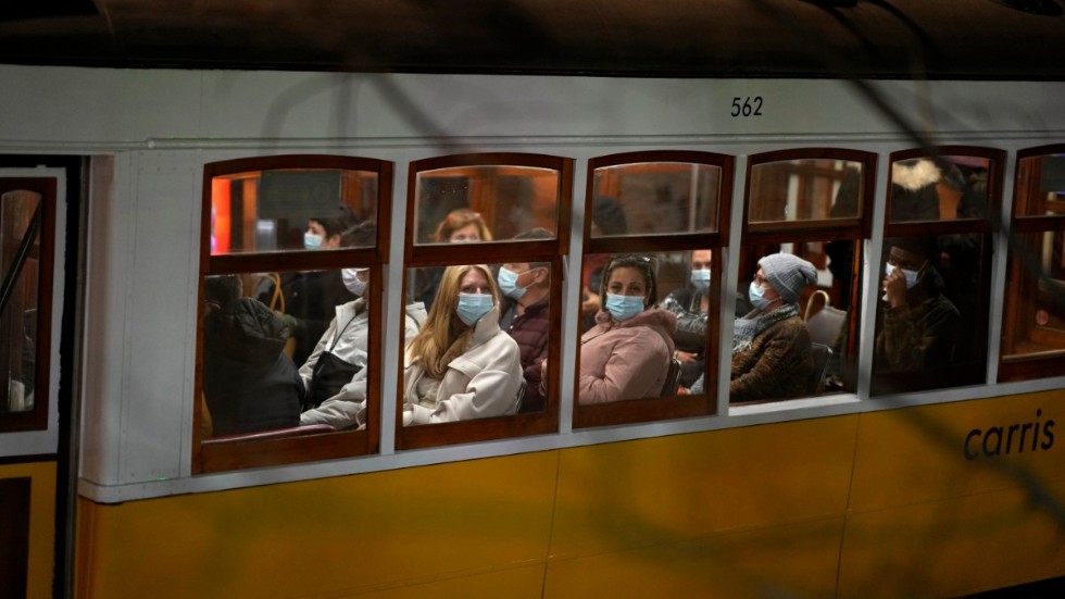 Passagerare med munskydd åker spårvagn i Lissabon, i fredags. Arkivbild.
