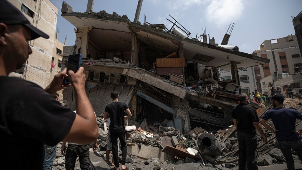 Palestinier inspekterar ett bostadshus i Gaza som skadats i en israelisk flygattack.