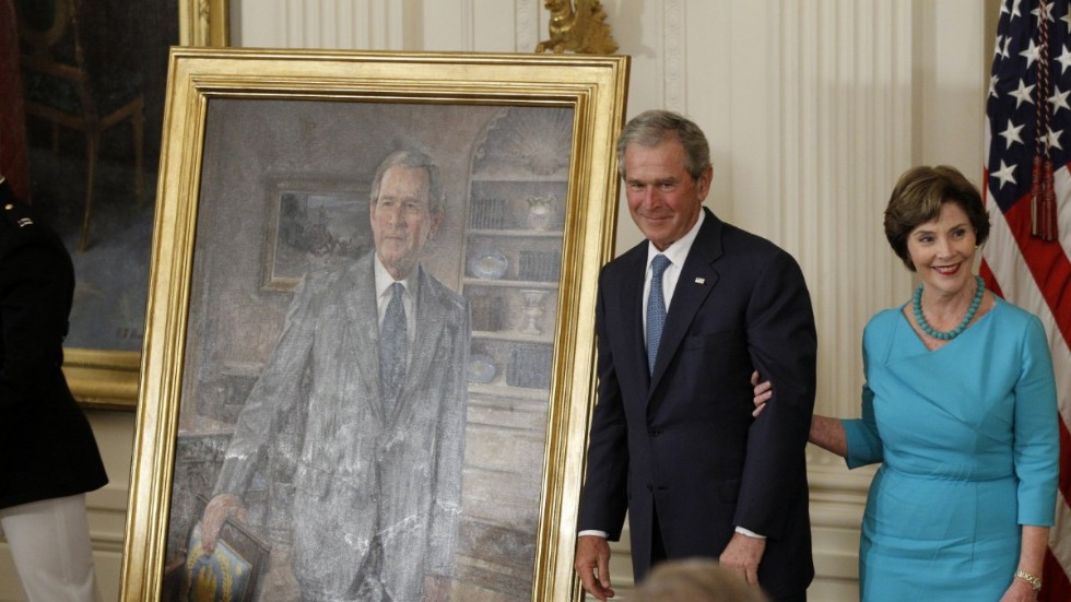 Det tidigare presidentparet George|W och Laura Bush avtäcker en porträttmålning i efterträdaren Barack Obamas vita hus 2012.