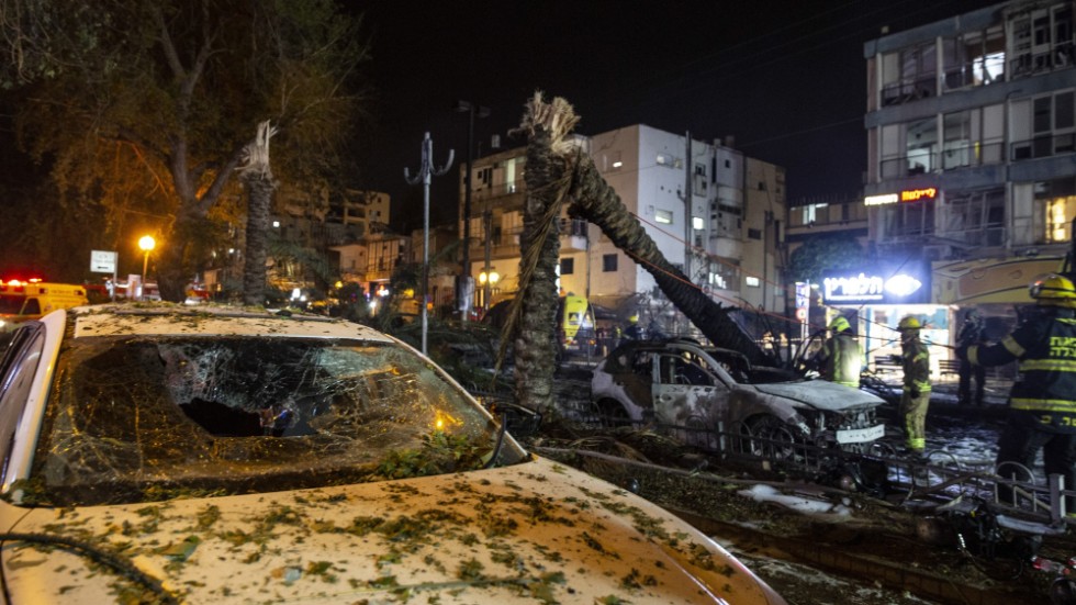 Israelisk räddningstjänst i staden Holon nära Tel Aviv arbetar med följderna av missilattacker från Hamas. 