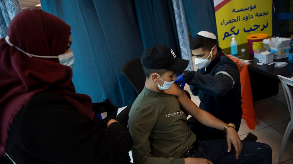 Ett israeliskt vårdlag ger vaccin till palestinier vid kontrollstationen Qalandia mellan Ramallah och Jerusalem.
