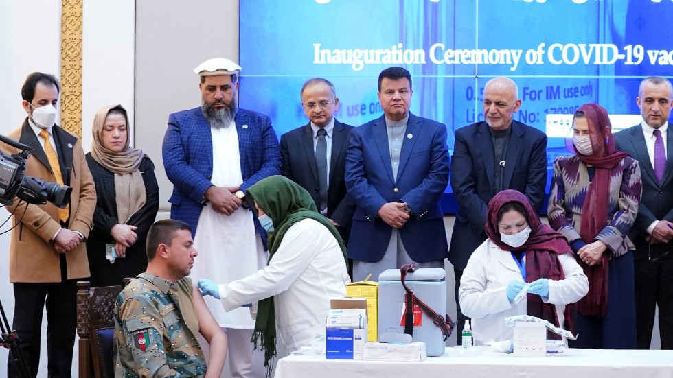 De första sprutorna med covidvaccin ges i Afghanistan, vid en ceremoni i presidentpalatset i Kabul. Tredje person från höger, som tittar på injiceringen, är president Ashraf Ghani.