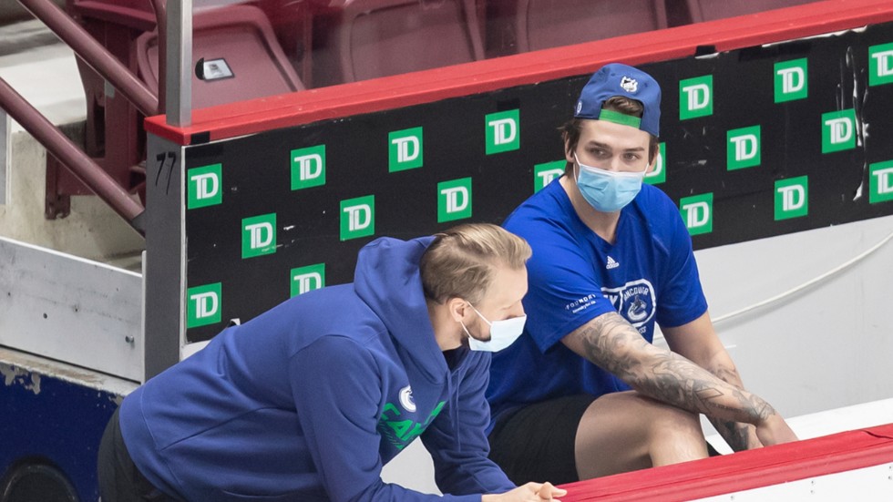 Vancouvers svenske backstjärna Alexander Edler, till vänster, och Jake Virtanen iförda munskydd under träningslägret inför NHL-säsongen.