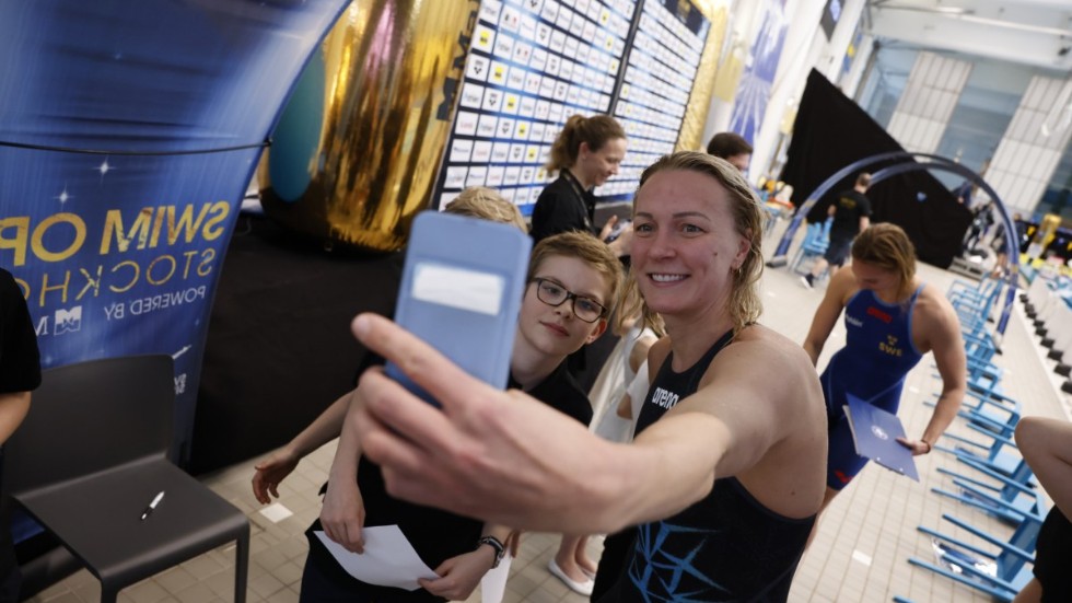 Sarah Sjöström tar en bild med ett par supportrar under Swim Open i Eriksdalsbadet.