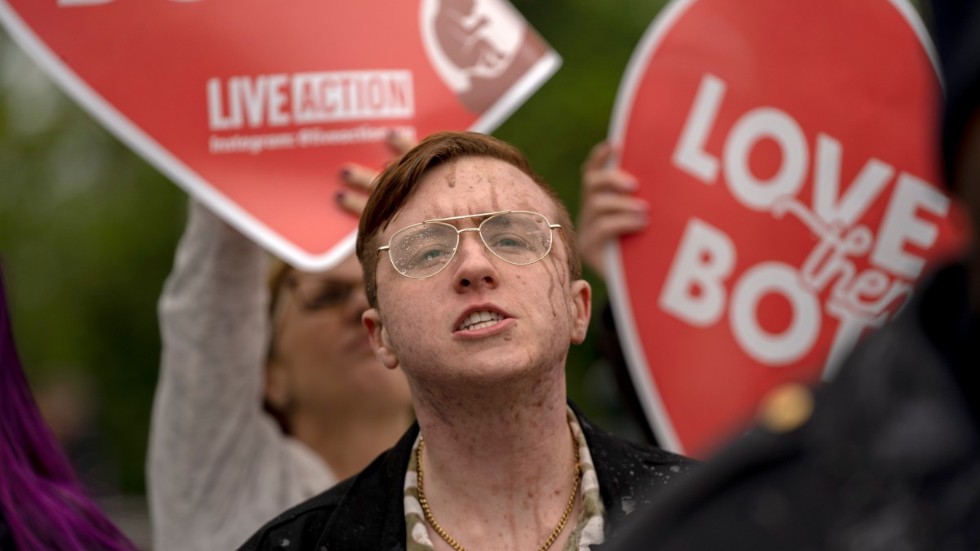 En man som demonstrerar mot aborträtten har fått chokladmjölk kastad på sig av demonstranter för abort i Washington.