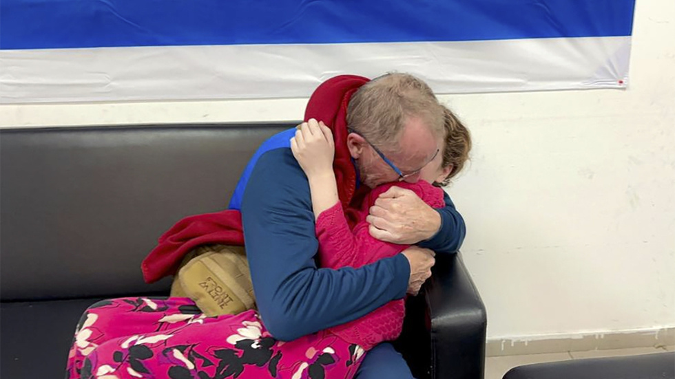 Thomas Hand kramar sin dotter Emily Hand efter att hon frigetts av Hamas. Fotot är distribuerat av Israels militär.