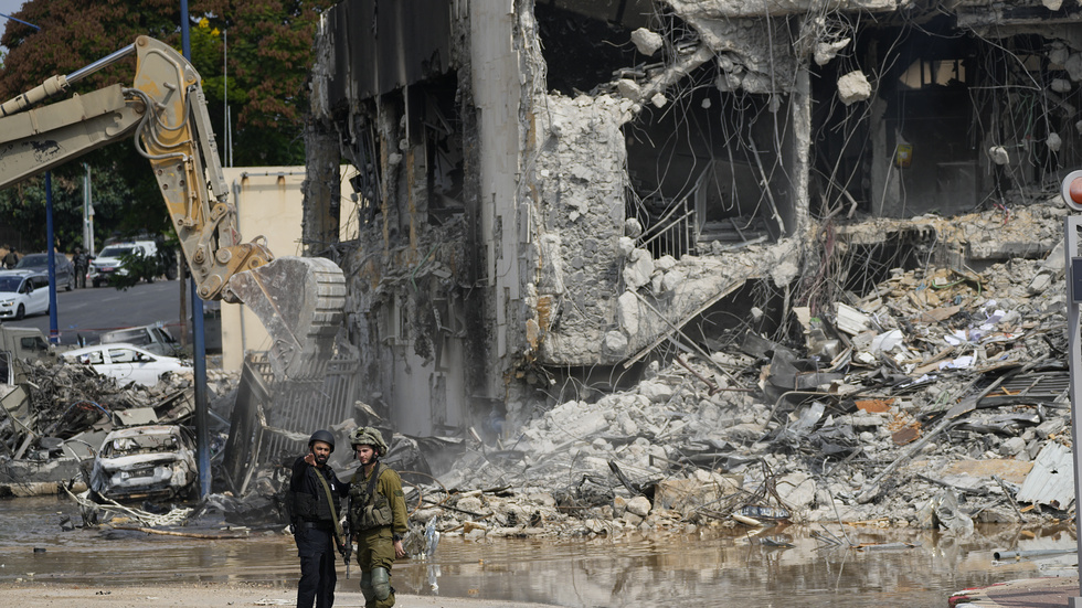 Två israeliska soldater betraktar förödelsen efter Hamas attack i Sderot.