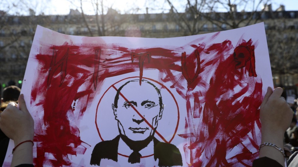 En Putinkritisk demonstrant håller upp en banderoll under en protest mot kriget i Ukraina i Paris i februari 2022.