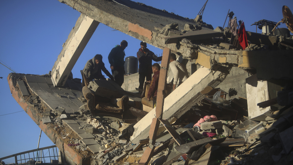 Palestinier inspekterar en förstörd byggnad i Gaza.