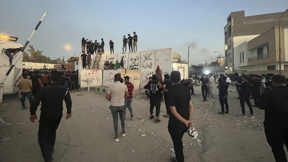 Demonstranter på en mur i närheten av Sveriges ambassad i Bagdad.