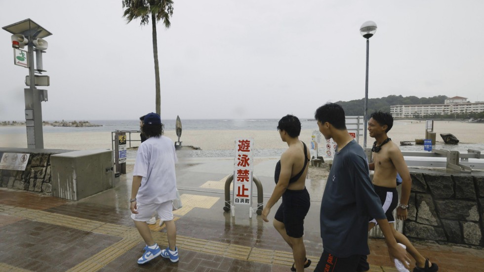 Japaner går förbi en strand som spärrats av inför tyfonens ankomst. Bilden är tagen i prefekturen Wakayama i måndags.