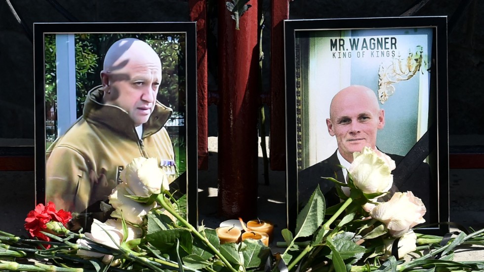 Porträttbilder av Jevgenij Prigozjin (vänster) och Dmitrij Utkin (höger) har ställts fram vid en minnesplats utanför ett av Wagnergruppens kontor, i Novosibirsk.