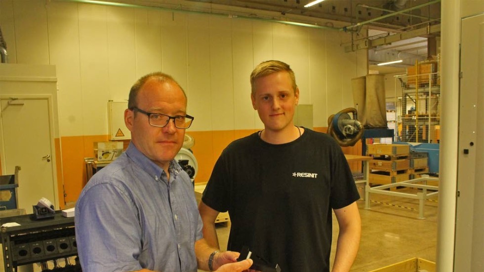 Per Alne och Erik Dyfverman står och inspekterar en färdig plastkomponent.