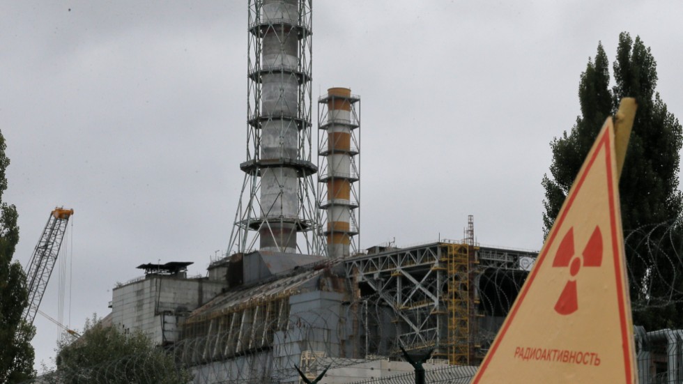 En skorsten som reser sig ur byggnaden med den skadade reaktorn i Tjernobyl.