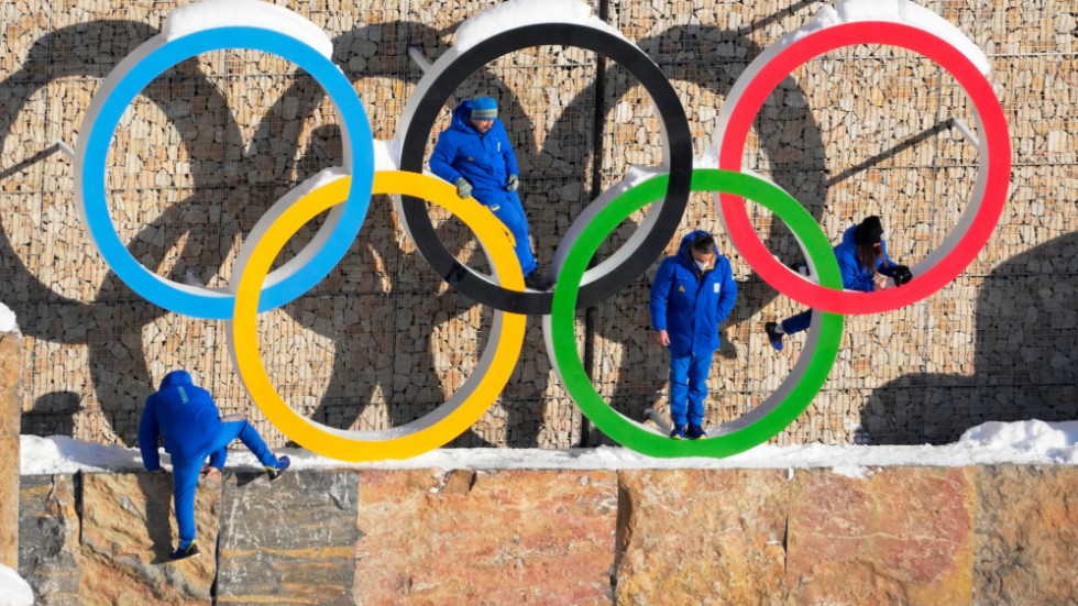 Personer ur den ukrainska OS-truppen poserar vid OS-ringarna i OS-byn i Yanqing i Kina.