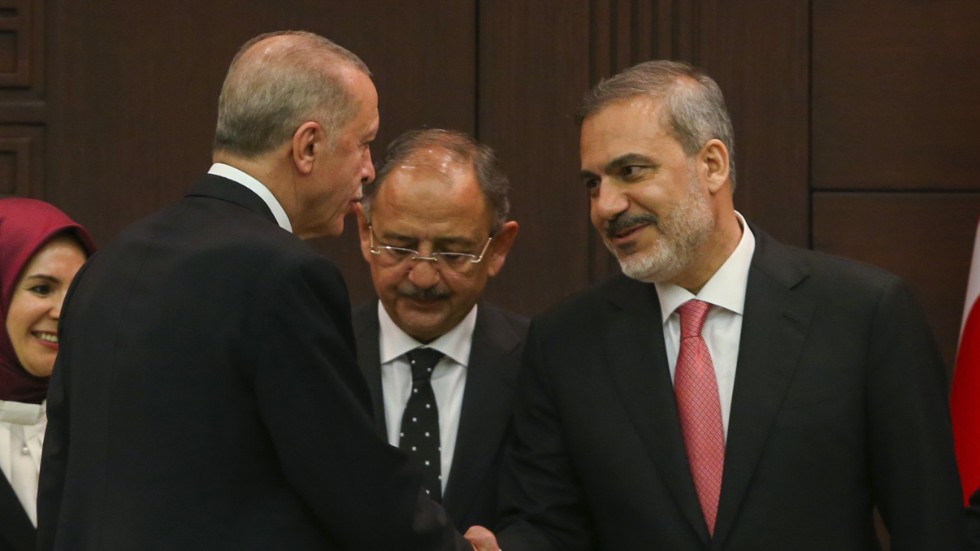 President Recep Tayyip Erdogan skakar hand med den nye utrikesminister Hakan Fidan i samband med att den nya regeringen presenterades i lördags. Arkivbild.