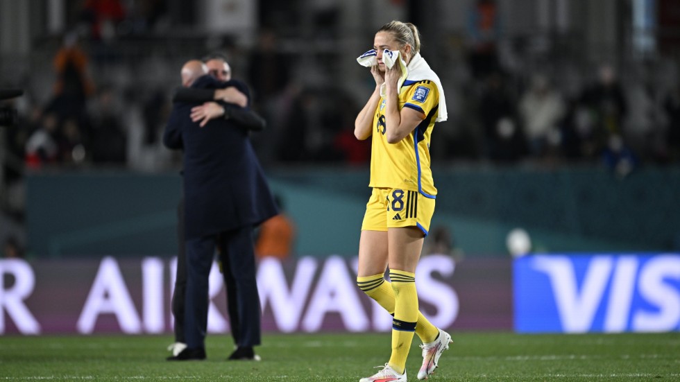 Sveriges Fridolina Rolfö efter 1–2-förlusten mot Spanien i semifinalen i fotbolls-VM på Eden Park i Auckland, Nya Zeeland. I bakgrunden syns Spaniens förbundskapten Jorge Vilda krama en kollega.