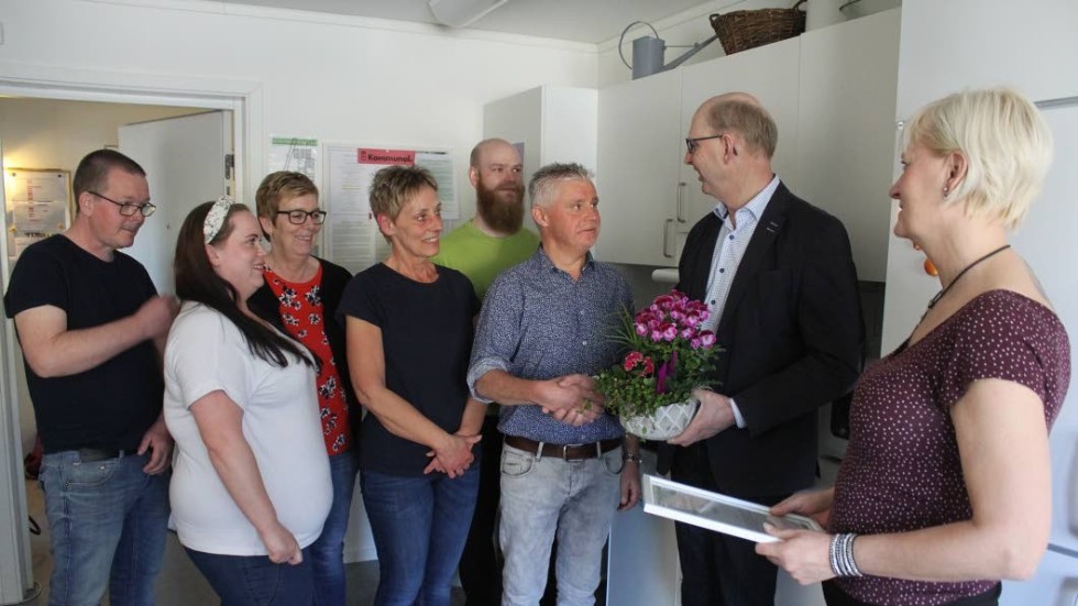 Per-Inge Pettersson och Jeanette Persson överlämnar diplom, blommor och pengar till personalen på Årets arbetsplats – gruppbostaden Berguven.