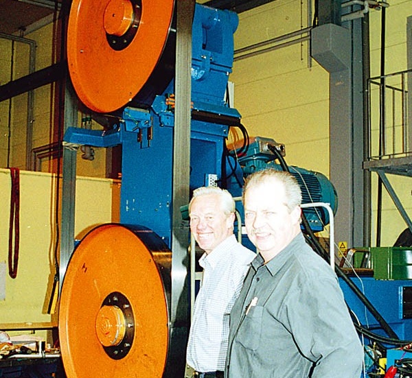 Bertil Lönnäs och Lennart Svensson vid en av de maskindelar, en nyutvecklad jättebandsåg som har målsättningen klarar 180 löpmeter per minut, som ingår i ett modernt sågverk.
