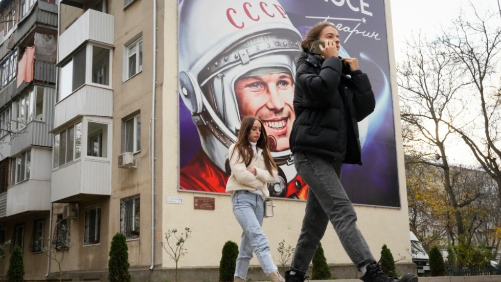 Två kvinnor passerar en anslagstavla prydd av den första kosmonauten Jurij Gagarin, i Transnistriens största stad Tiraspol. Bilden är tagen i november 2021. Arkivbild.