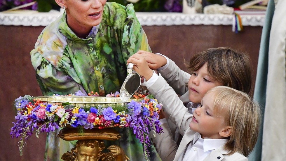 Faddern Frida Vesterberg får hjälp av prins Alexander och prins Gabriel att hälla vatten i dopfunten vid prins Julians dop i Drottningholms slottskyrka.