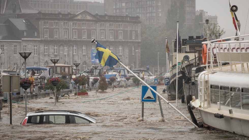 En svensk flagga som av någon anledning hissats vid Meusefloden i belgiska Liège är på väg att rasa i stigande vattennivåer. Arkivbild från den 15 juli.