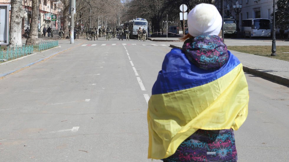 En kvinna i Cherson insvept i en ukrainsk flagga protesterar mot den ryska ockupationsmakten. Bilden är tagen 19 mars.
