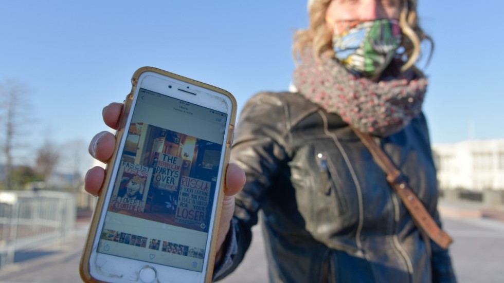 Nicky Sundt var en av få motdemonstranter på plats under onsdagen och visar upp en bild på sin telefon där hon bär en skylt med texten ”Republikanerna är slut”.